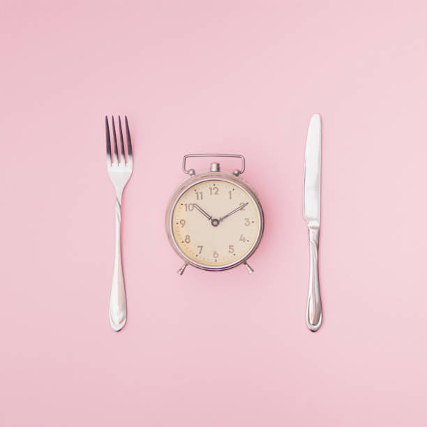 старые часы, нож и вилка на розовом фоне. минимальный состав. копирование пространства. - box lunch education retro revival стоковые фото и изображения
