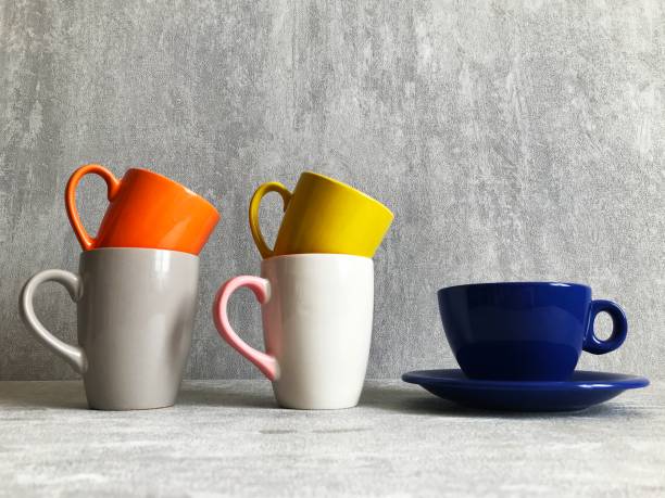 istock Colorful coffee cups on wooden table over grunge background 1310909777