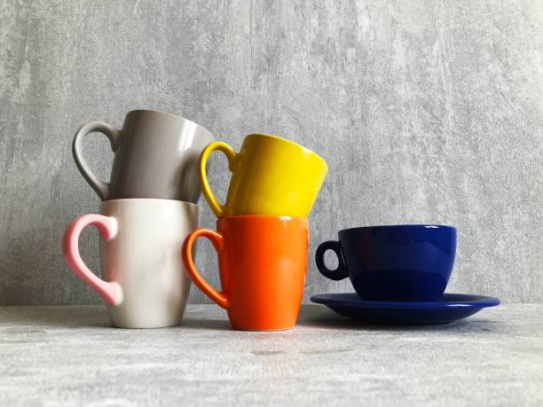 istock Colorful coffee cups on wooden table over grunge background 1310909778