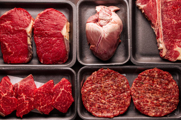 istock Black plastic packaging trays from supermarket with different types of fresh raw meat cuts, fresh beefbeef steaks and variety meats in boxes from above 1310910486