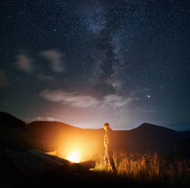 istock Man standing and enjoying bonfire and nature. 1310912176