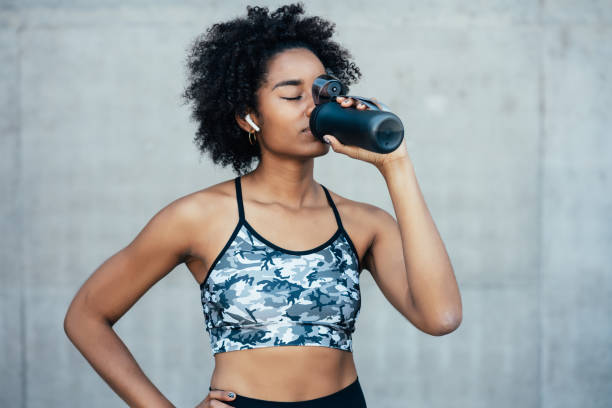 istock Athletic woman drinking water after work out outdoors. 1310914645
