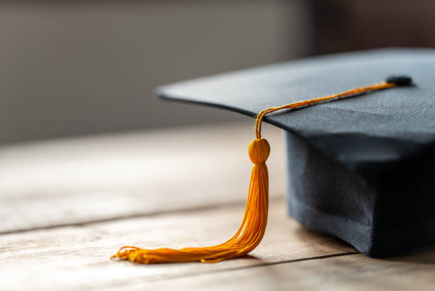 fermez-vous vers le haut du chapeau noir de graduation et du gland jaune - toque de diplômé photos et images de collection