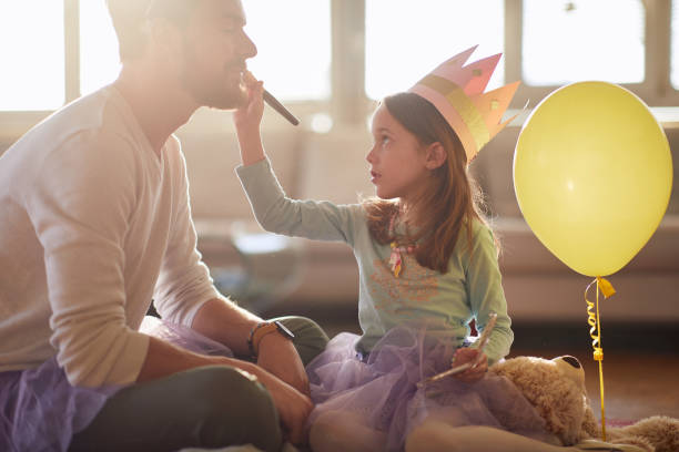 istock A little ballerina who puts makeup on her father's face while they are preparing for a training at home. Family, ballet, training 1310918587