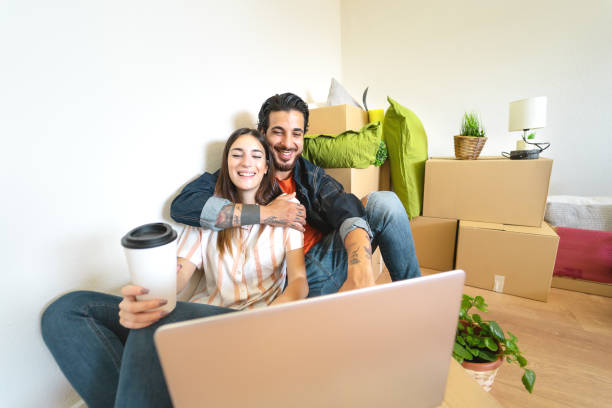 Happy young couple moving in new home first time - Man and woman having fun using computer next carton box in new property house - Change apartment day and people lifestyle relationship concept feliz pareja joven que se muda en nuevo hogar por primera vez - hombre y mujer divirtiéndose usando la siguiente caja de cartón de la computadora en la nueva casa de la propiedad - cambiar el día del apartamento y la gente concepto de relación de estil