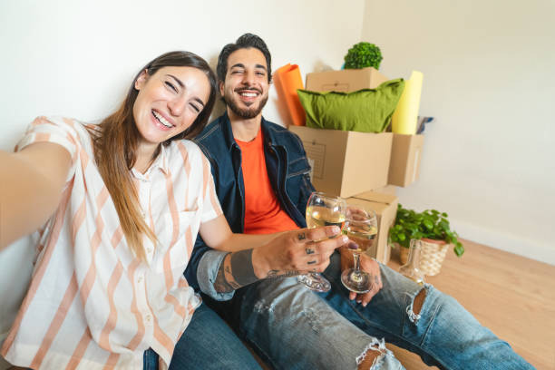 istock Happy young couple taking selfie while celebrating with champagne in new home first time - Change apartment day and people lifestyle relationship concept 1310920090