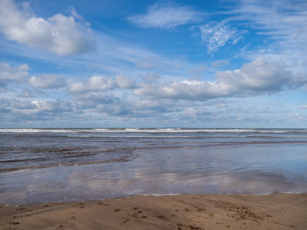 istock Beautiful empty beach with tide coming in, blue sky in winter, UK. 1310922340