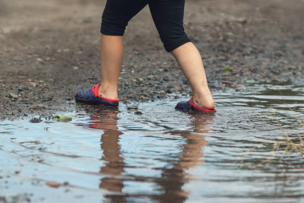 istock Children's feet walking in a muddy puddle after the rain 1310923184
