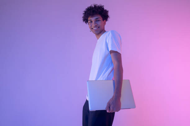 istock Dark-skinned young guy in white tshirt with a laptop 1310925967
