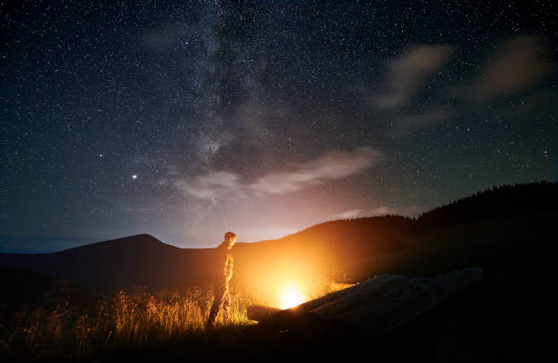 istock Man iswalking in mountains and lighting bonfire. 1310925988