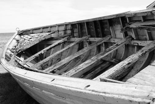 Black and White picture of an old abandoned fishing boat stranded on a beach in Mauritius