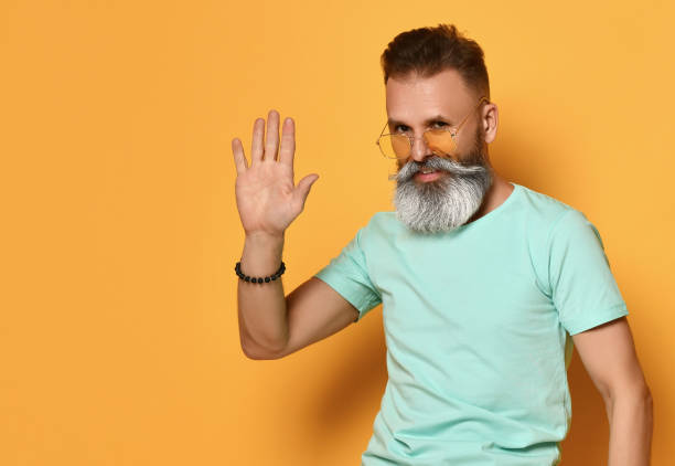 istock Positive smiling bearded man greeting gesture studio shot 1310927427