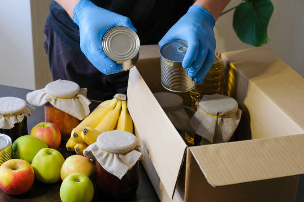 istock A volunteer wearing protective gloves puts food in a donation box. Delivery during quarantine. Concept of assistance during quarantine due to coronavirus infection 1310932508