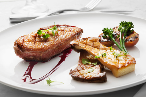 Pan Seared Crispy Duck Breast with a Beet Gastrique, Seared Oyster Mushrooms, Roast Cherry Tomatoes and Broccolini