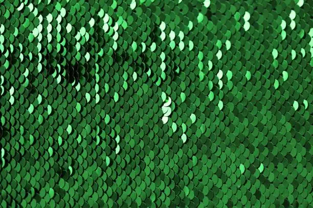 Photo of Sequins green shiny background.sequin pattern.Texture scales with Sequins close-up.Scales background.Shiny texture material.sparkling sequined textile