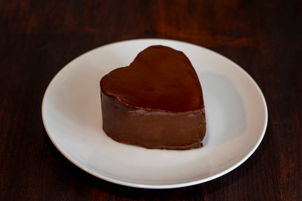 istock Heart shaped chocolate cake on plate on dark wooden background 1310932745