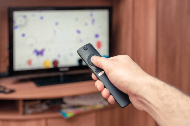 istock A man with a remote control in his hand is watching TV 1310934676