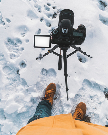 blogger photographer winter time copy space screen camera tripod footprints in the snow