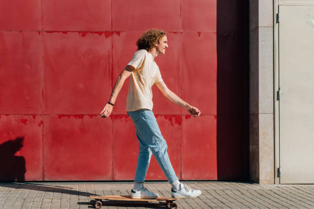 Young man skating on the city on a summer day
