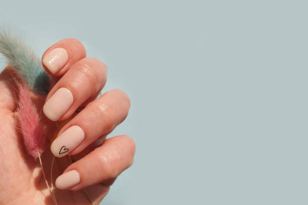 istock female hand beautiful beige manicure on a colored background 1310937637