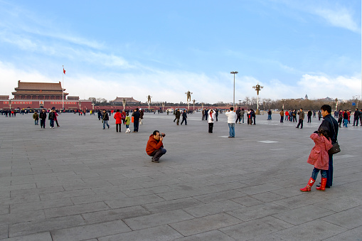 Chinese tourists taking photos at the Tiananmen Square in Beijing, in front of the entrance gate of the Forbidden City.