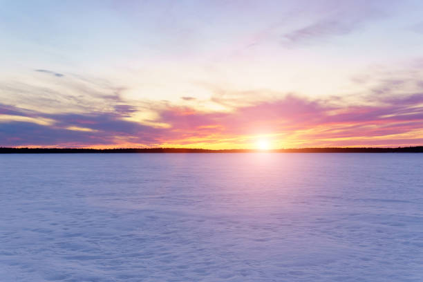 istock Winter landscape on a frozen lake, forest, flying clouds at sunset. 1310938902