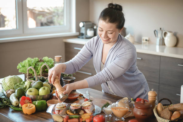 istock woman cooking in the kitchen ( with fish salmon) 1310938955