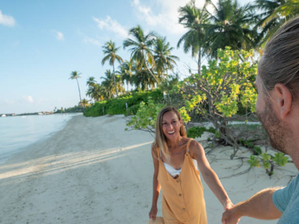 istock Side view of couple holding hands on tropical beach 1310940653
