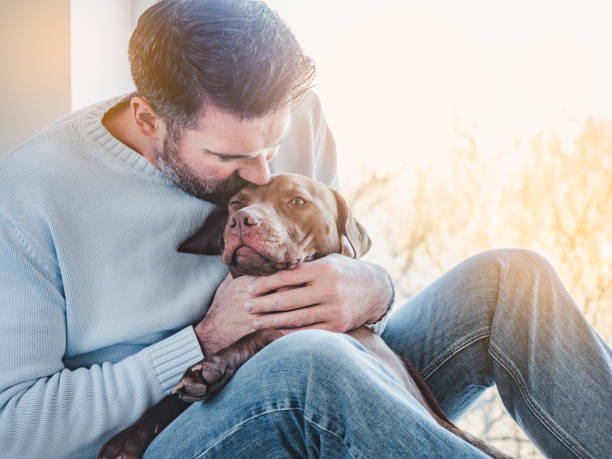 istock Handsome man and a charming puppy. Closeup 1310943984