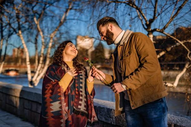 istock Man giving a rose to his girlfriend on a date 1310947153
