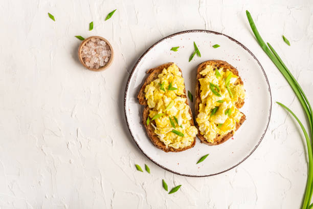 istock Scrambled Eggs on wholewheat toast. Delicious breakfast or snack on a light background, top view, copy space 1310947392