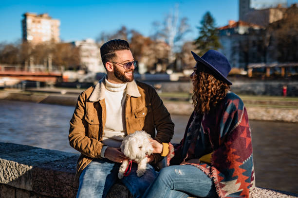 istock Couple with dog enjoying on riverbank 1310948776