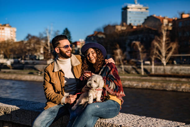istock Couple with dog enjoying on riverbank 1310949009