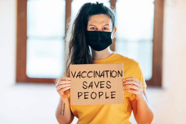 istock woman with face mask holding a banner 1310949448