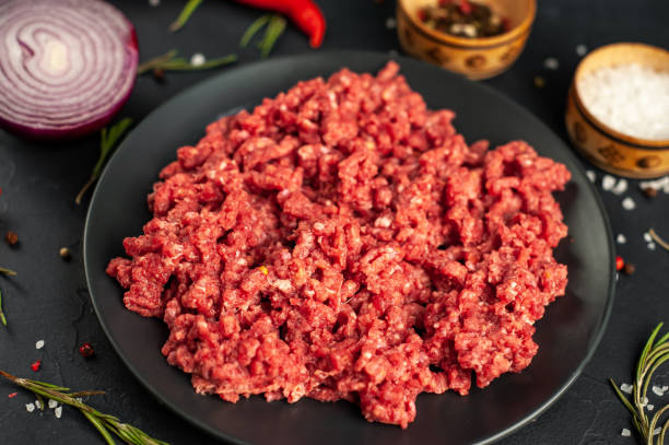 istock Fresh raw minced beef with herbs and spices on a black plate on a stone background 1310950324