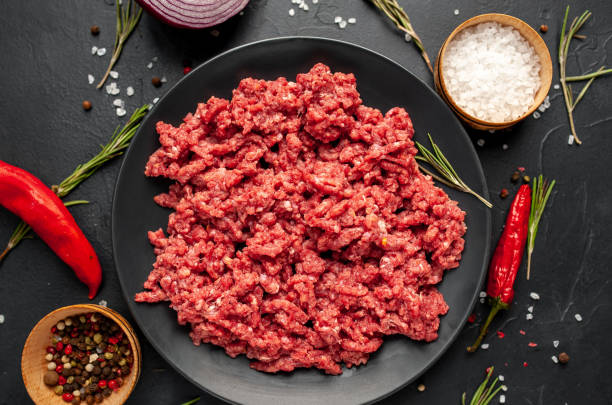 istock Fresh raw minced beef with herbs and spices on a black plate on a stone background 1310950338