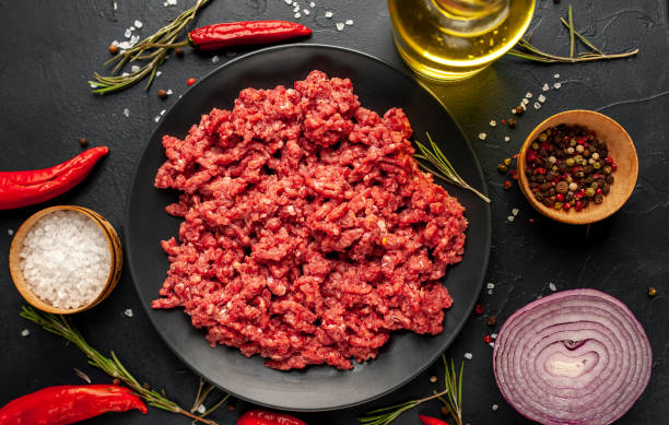 istock Fresh raw minced beef with herbs and spices on a black plate on a stone background 1310950363