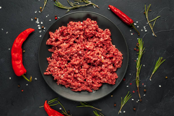 istock Fresh raw minced beef with herbs and spices on a black plate on a stone background 1310950386
