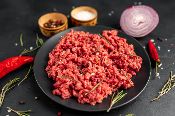 istock Fresh raw minced beef with herbs and spices on a black plate on a stone background 1310950410