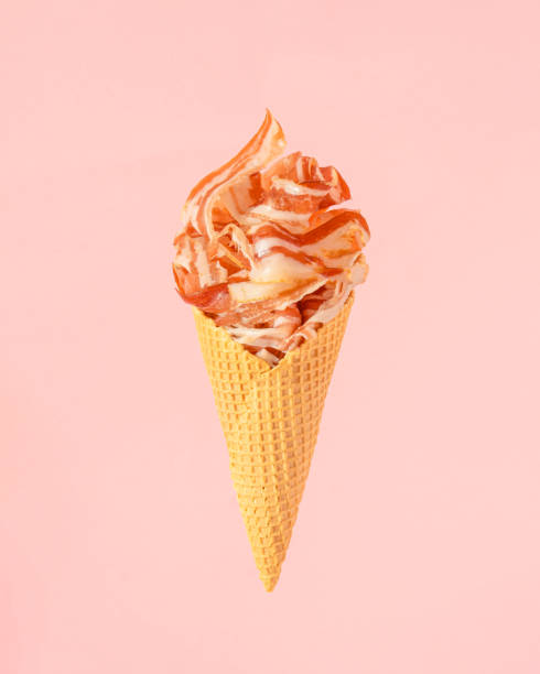 Minimal  composition with ice cream cone full of fresh bacon against pastel pink background. Creative summer bbq concept.