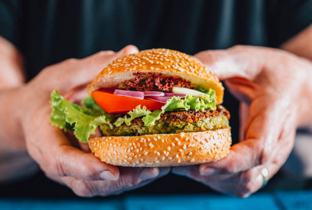 istock Holding a Vegan Burger 1310953251
