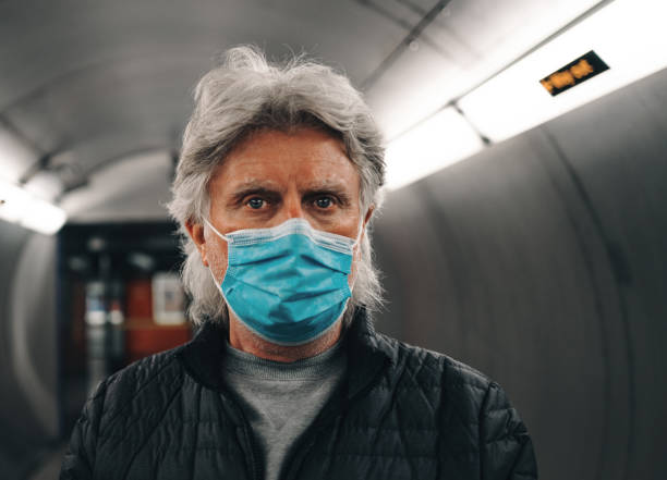 istock Senior man wearing face mask in modern subway station 1310953324