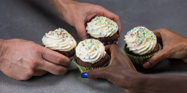 istock Close-up of hands holding cream-filled cupcakes. 1310953382