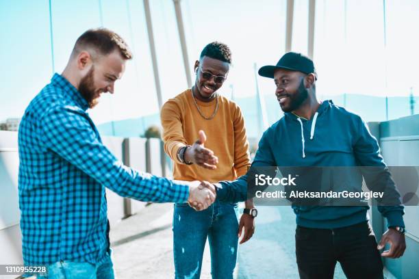 Caucasian And African Males Take Bet While Another African Friend Cuts