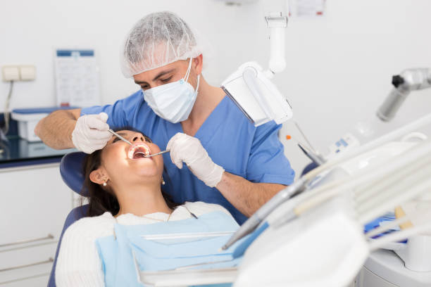 istock Dentist man examining a latin female patient teeth 1310958147