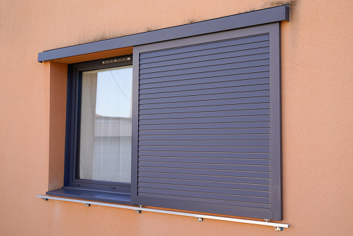 home windows with modern sliding shutters in house facade