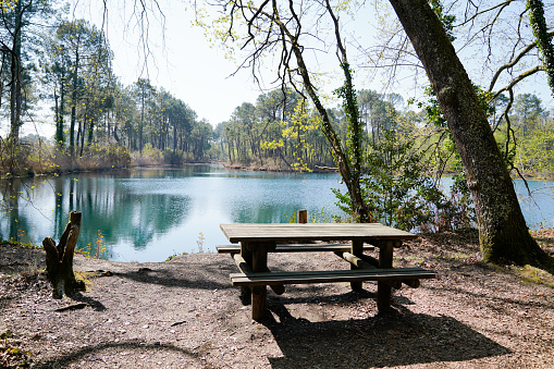 Wooden picnic table in lake side coast landscape background