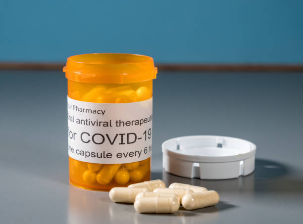 Concept of a new oral antiviral therapeutic treatment for Covid-19 virus Prescription bottle and capsules illustrating trials of oral antiviral treatment for SARS-CoV-2 or Covid-19 virus antiviral drug stock pictures, royalty-free photos & images
