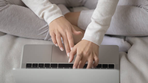 istock Busy young female freelancer sitting cross-legged on couch using laptop 1310961721