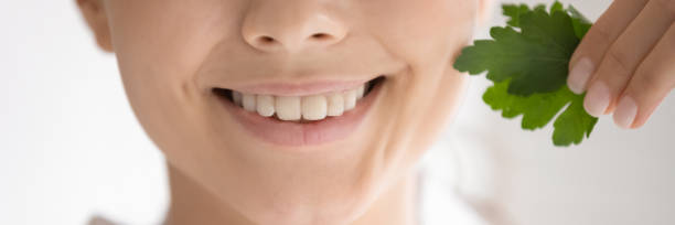 istock Young lady demonstrating healthy teeth showing fresh parsley leaf 1310961794